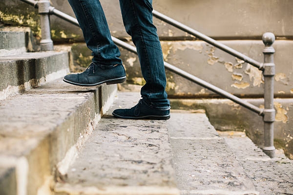 Close-up of man's shoes walking upstairs
